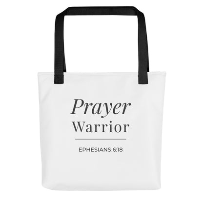 Front view of a white tote bag with black handles featuring “Prayer Warrior” and “Ephesians 6:18” in dark gray.
