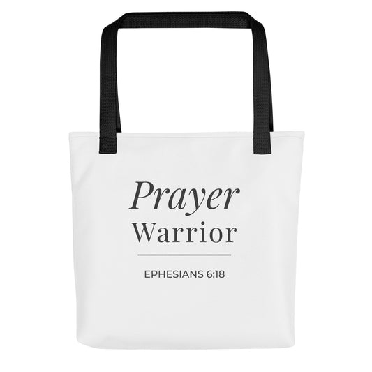 Front view of a white tote bag with black handles featuring “Prayer Warrior” and “Ephesians 6:18” in dark gray.