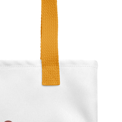 Close-up of the white tote fabric and mustard yellow strap, highlighting the stitching, textured canvas, and strap weave detail.