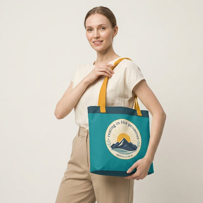 Model carrying a teal Christian tote bag with yellow handles and a faith-inspired mountain design featuring Matthew 11:28-30.