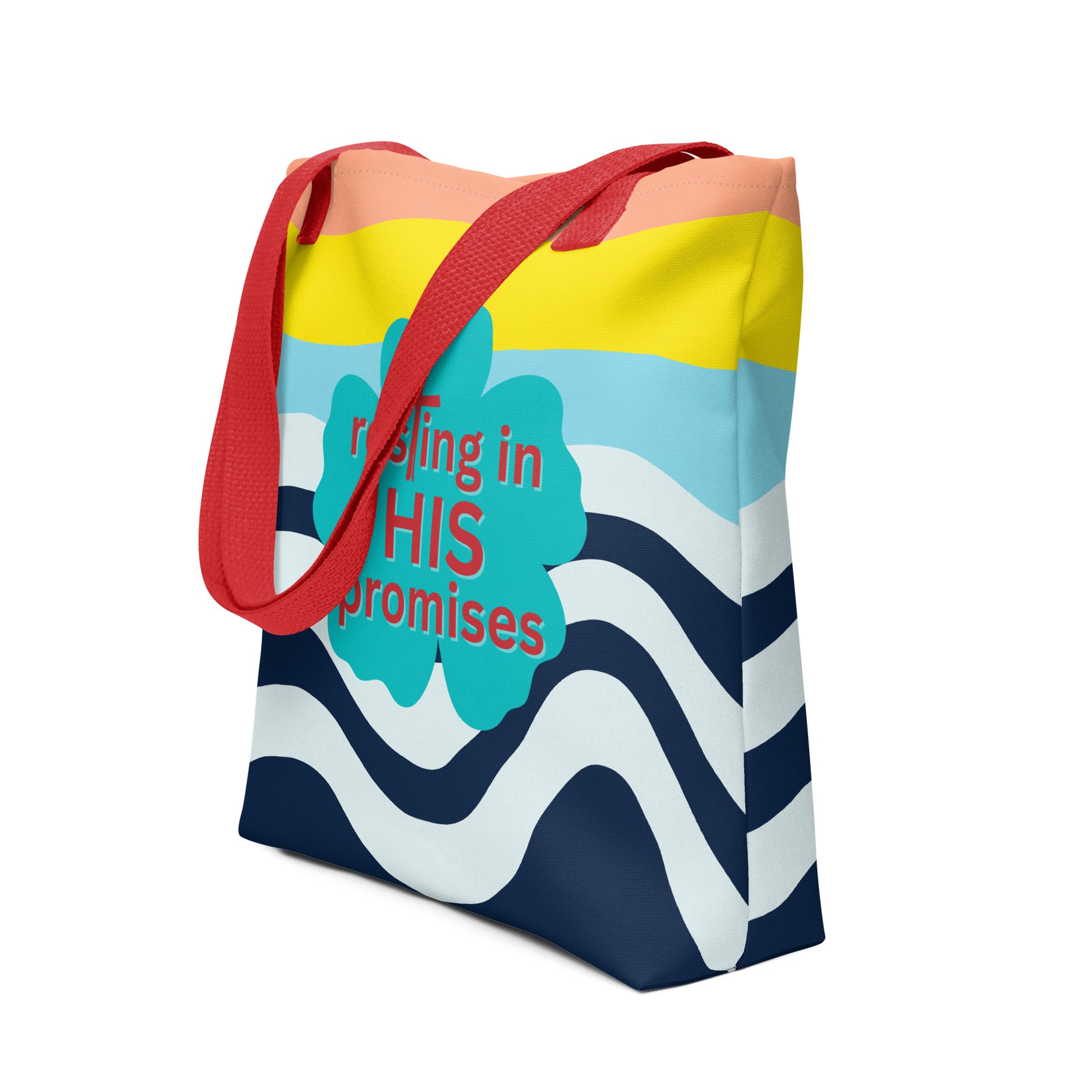 Angled view of tote bag with red straps, peach and yellow top bands, navy wave print, and “resting in HIS promises” clover design.