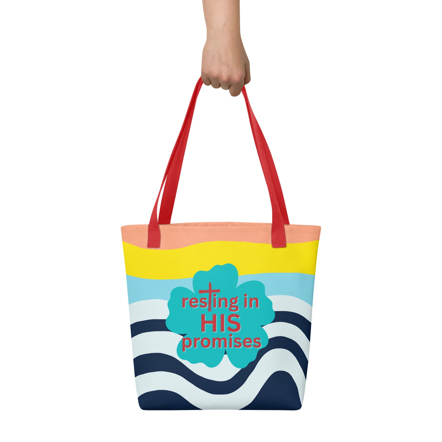 Hand holding tote bag with red straps, colorful wave stripes, and teal clover print that says “resting in HIS promises.”