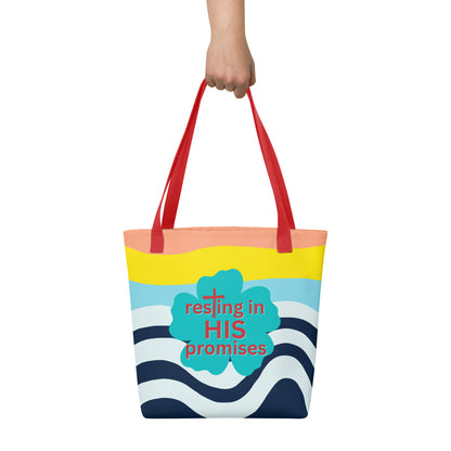 Hand holding tote bag with red straps, colorful wave stripes, and teal clover print that says “resting in HIS promises.”