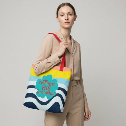 Lifestyle photo of a person carrying the tote bag with red straps, wavy stripe design, and teal “resting in HIS promises” clover graphic.
