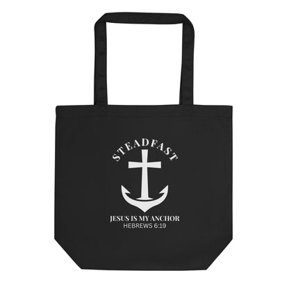 Black cotton tote bag with a white anchor-and-cross graphic, “STEADFAST” above, and “Jesus is my anchor — Hebrews 6:19” below.