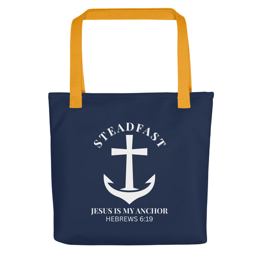 Front view of a navy blue Christian tote bag with mustard yellow straps, featuring a white anchor-and-cross graphic and the text “STEADFAST” and “JESUS IS MY ANCHOR” with “HEBREWS 6:19” below.