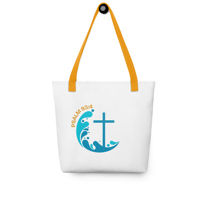 White tote bag hanging on a hook with yellow handles, “Psalm 93:4,” and a blue wave-and-cross symbol.