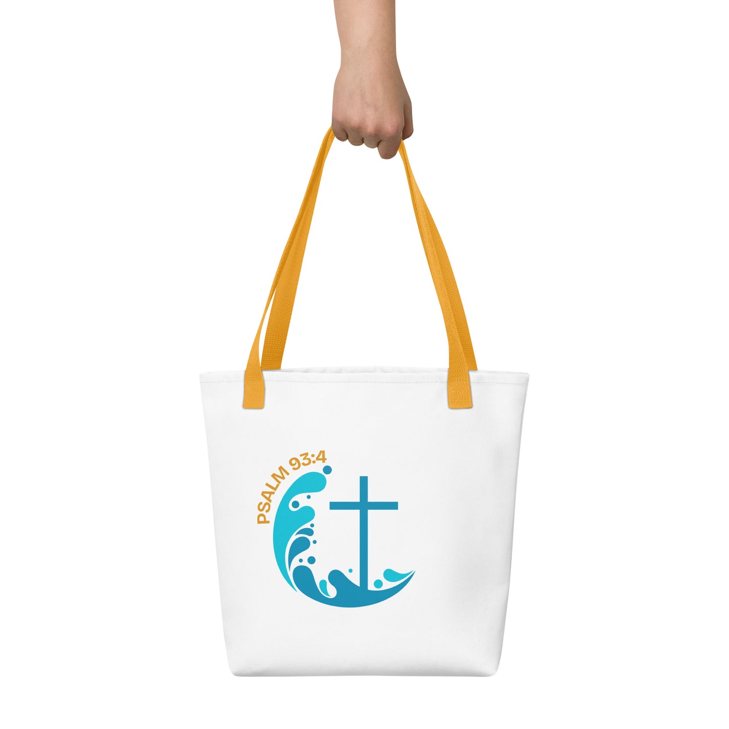 White tote bag held in hand with yellow straps featuring “Psalm 93:4” and a blue wave graphic with a cross.