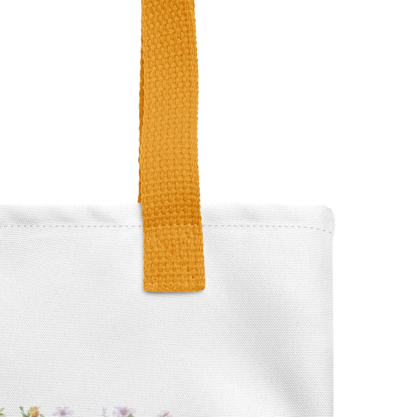 Close-up of the tote’s canvas texture and yellow strap stitching with part of the “WORSHIP over worry” floral framed design visible.